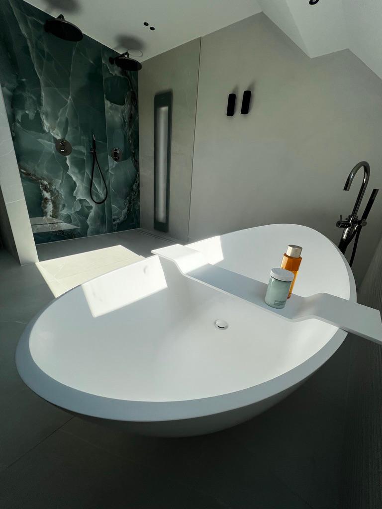 Badkamer met vrijstaand bad en grootformaat slabs